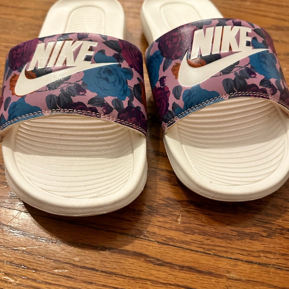 Nike slides size US9, is white with many different colors.